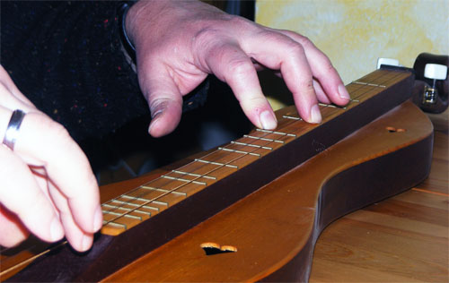 Picking mit der rechten Hand, w&auml;hrend die linke Hand Akkorde greift